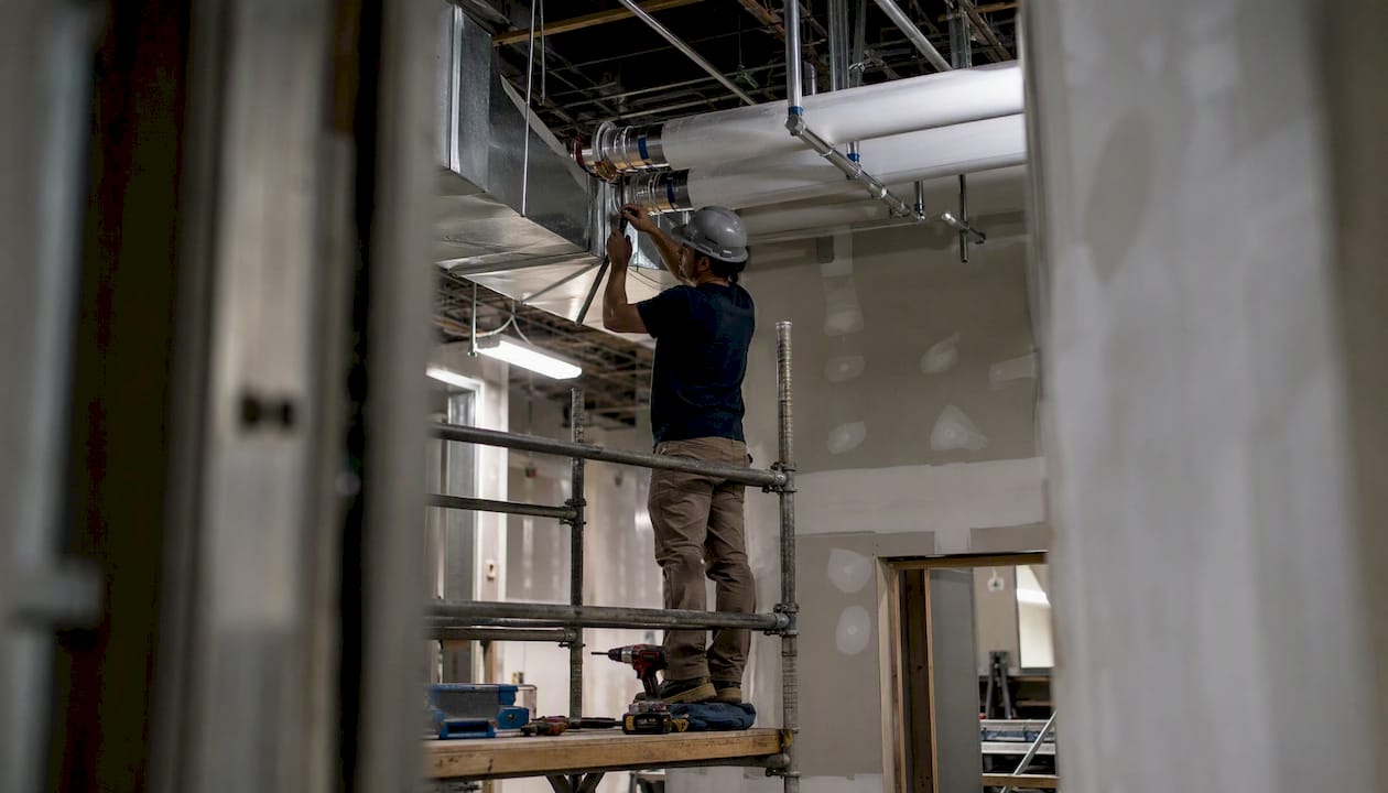 Hands installing medical HVAC ductwork