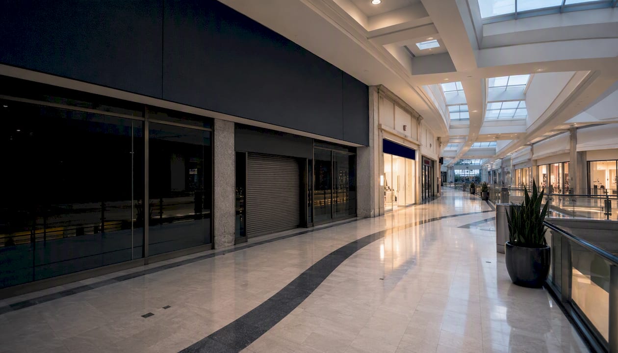 Empty dark anchor store in mall corridor