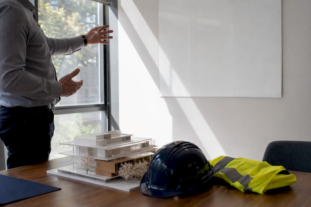Hands pointing at blank whiteboard and tablet in office