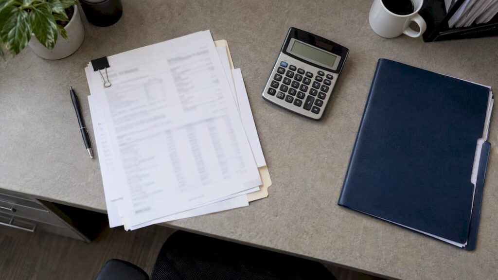 Lease reconciliation papers and calculator on desk
